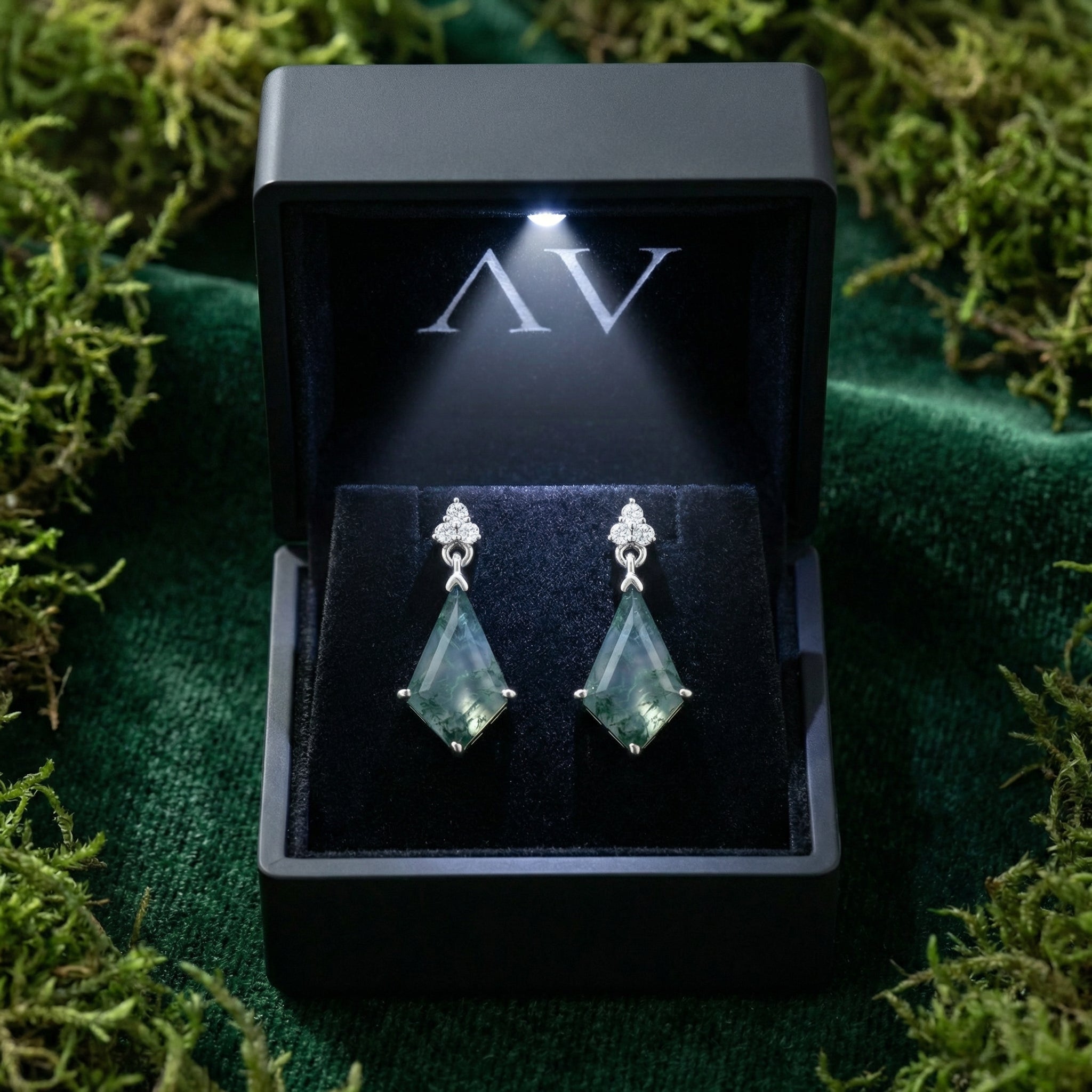 Kite cut moss agate drop earrings in sterling silver inside a black jewelry box with an integrated LED light.