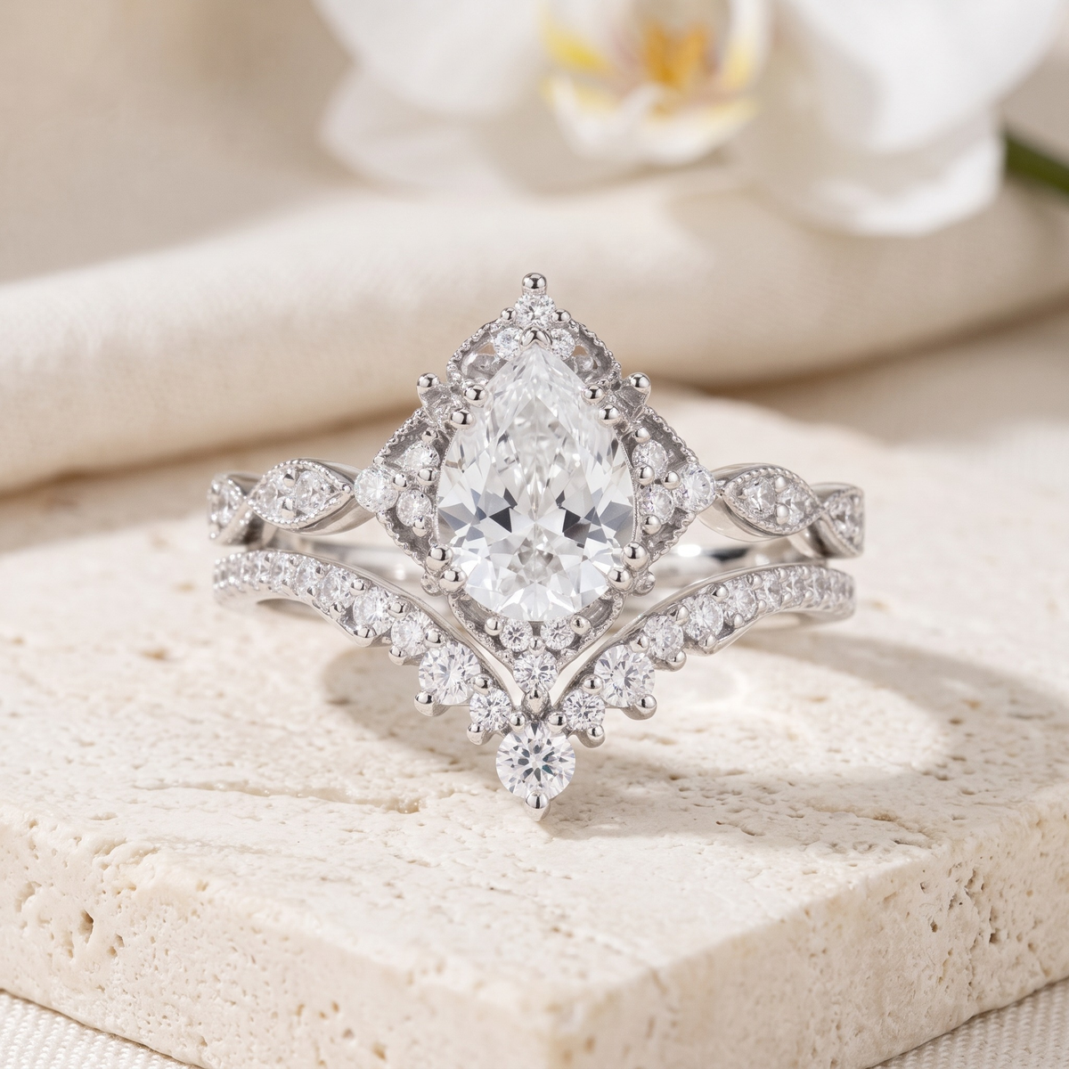 Vintage pear-cut ring and matching curved band in silver, front product view.