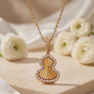 Close-up of the gold-tone Sorsha pendant displaying its sunburst texture and cubic zirconia halo.