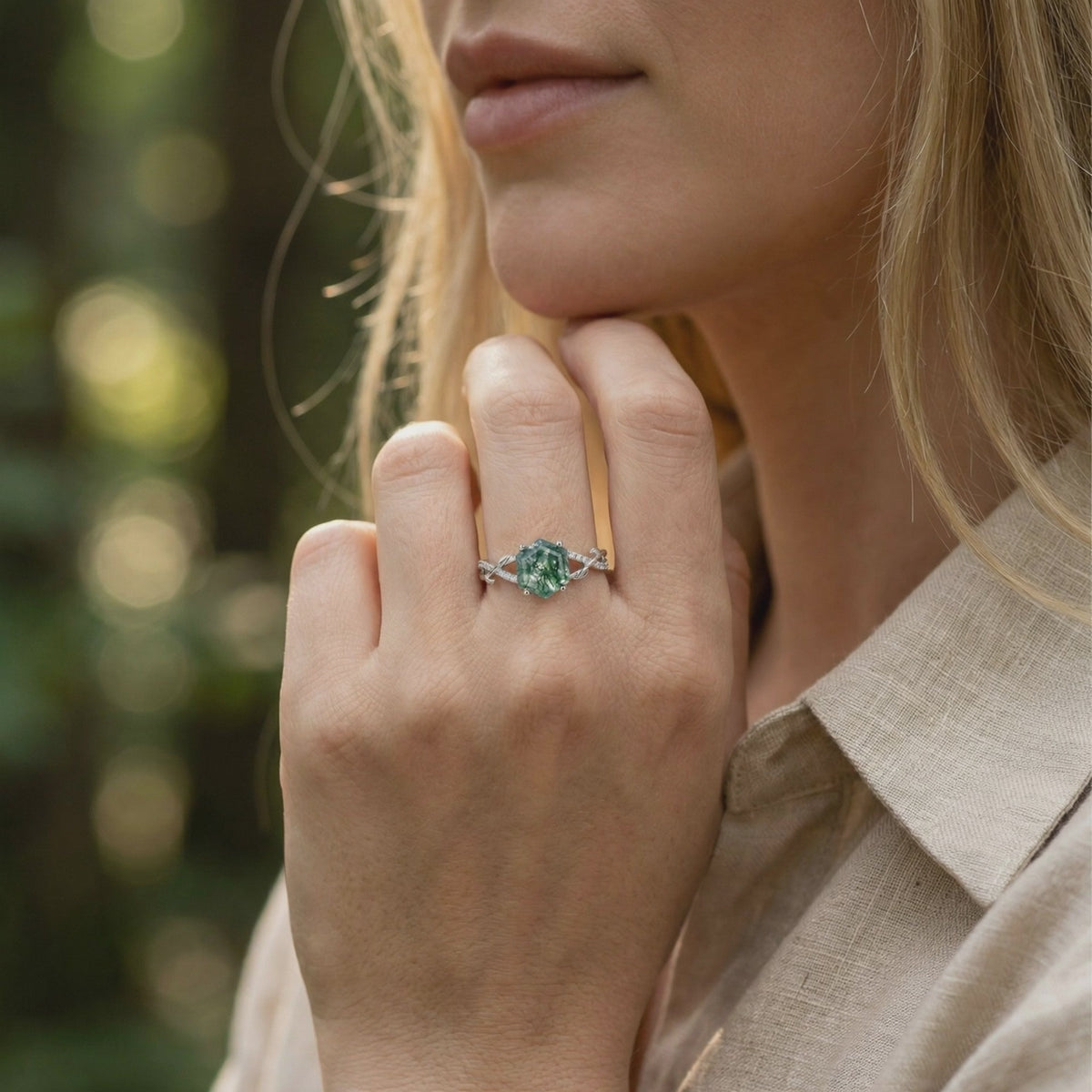 Model wearing a solid gold (white gold) hexagon moss agate ring with moissanite accents.