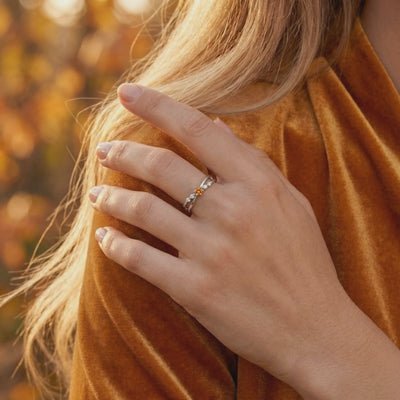 Solid white gold crossover ring featuring a simulated topaz.