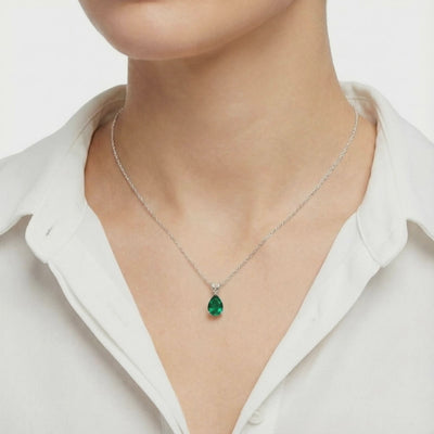 Video of a solid gold necklace with a pear-cut green moissanite pendant.