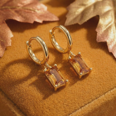 Solid gold drop earrings with simulated topaz.