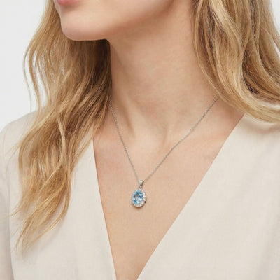 Simulated aquamarine halo pendant necklace in solid gold.
