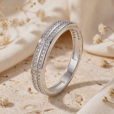 The Margaux double-row pavé silver ring with clear stones, standing upright on a pale textured surface.