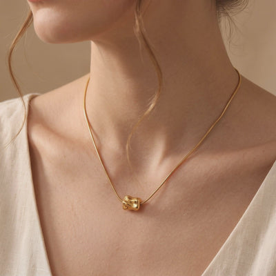 Close-up video preview of a person wearing a gold snake chain necklace with an organic molten pendant.