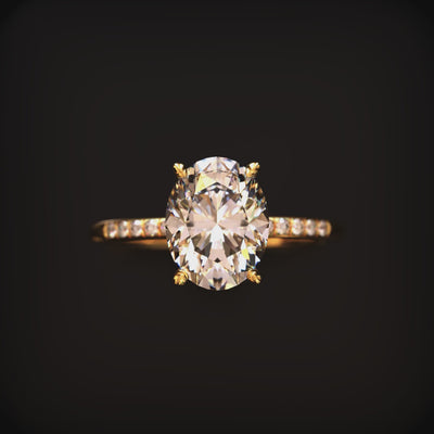 A solid gold ring with a 2 carat oval moissanite and pavé band.