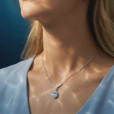 Aquamarine oval halo necklace in solid gold.
