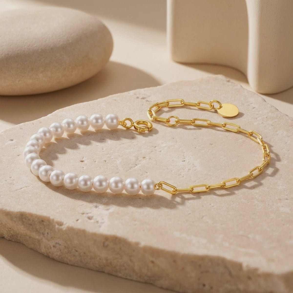 Video of the solid gold pearl bracelet laid out on a beige stone slab.