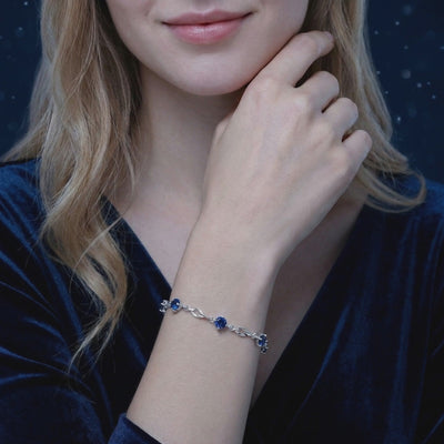 Solid gold station bracelet with simulated sapphires.
