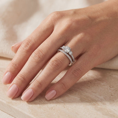 Silver three-stone ring set with a pavé band, shown worn on a hand.