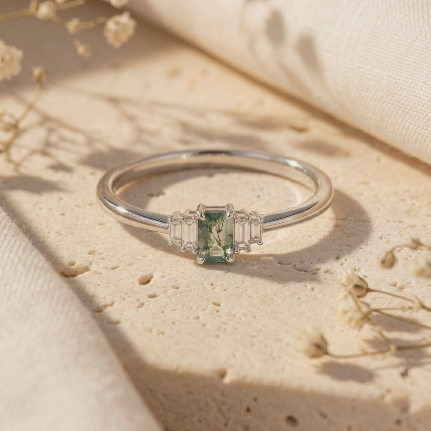 Solid gold ring with emerald-cut moss agate and baguette accents.