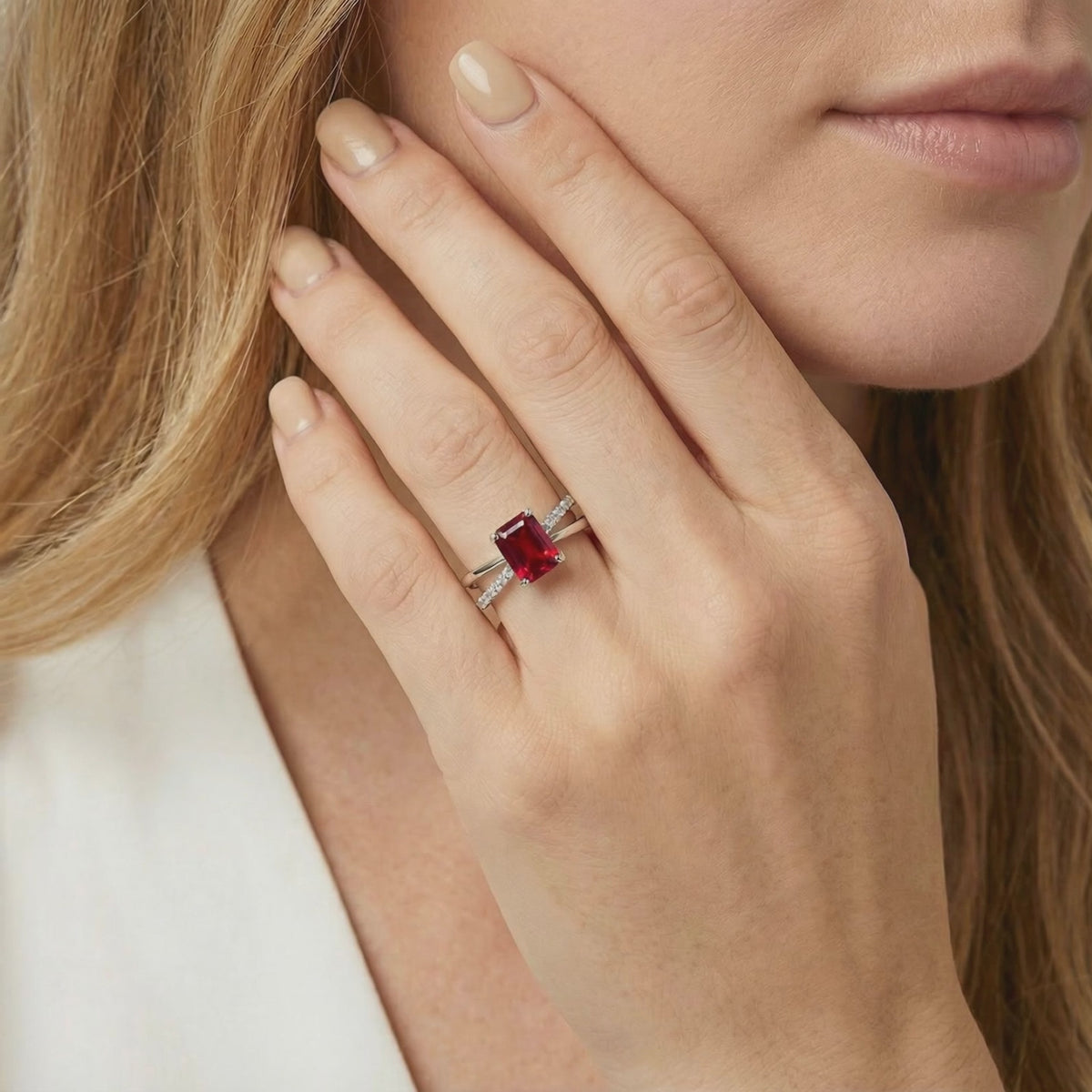 A solid gold ring featuring a radiant cut simulated ruby.