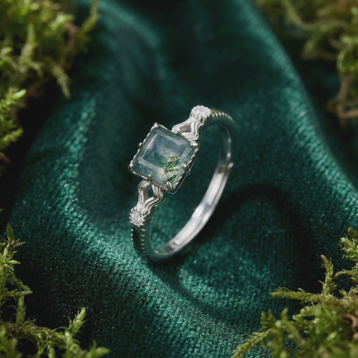 A solid gold cushion cut natural moss agate ring with a wavy band.