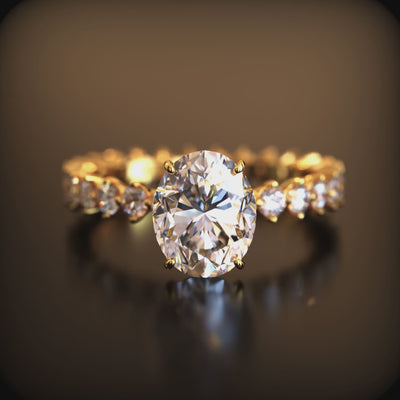 A solid gold ring with a 2 carat oval moissanite center stone.