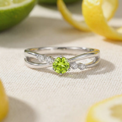 Zelinda bypass ring in solid gold with a simulated peridot.