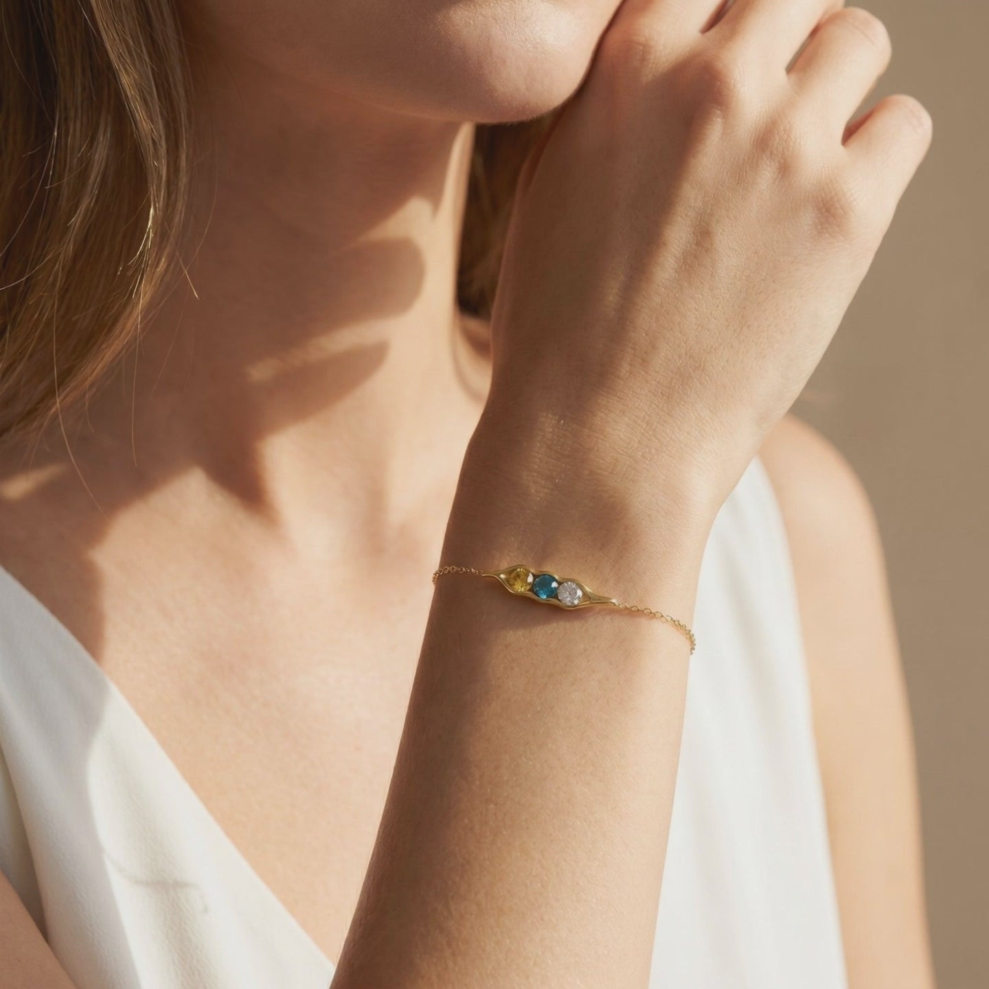 The Adelaide solid gold pea pod bracelet featuring simulated birthstones.