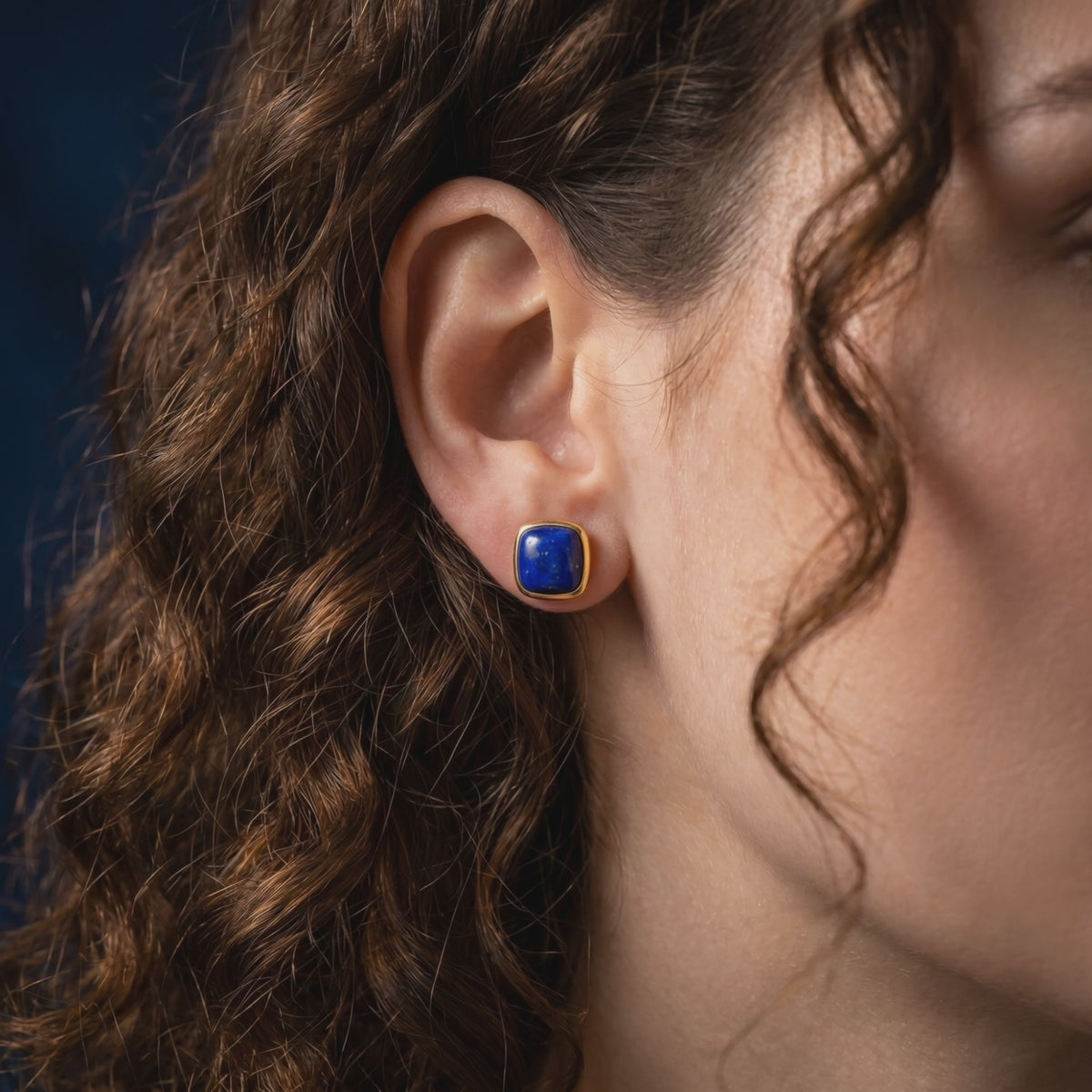 A yellow gold cushion-cut lapis lazuli earring, a type of solid gold earring.