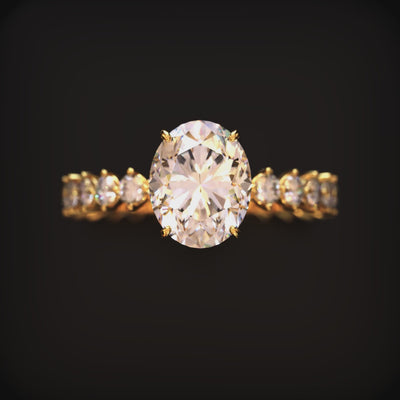 A solid gold ring with a 2 carat oval moissanite center stone.