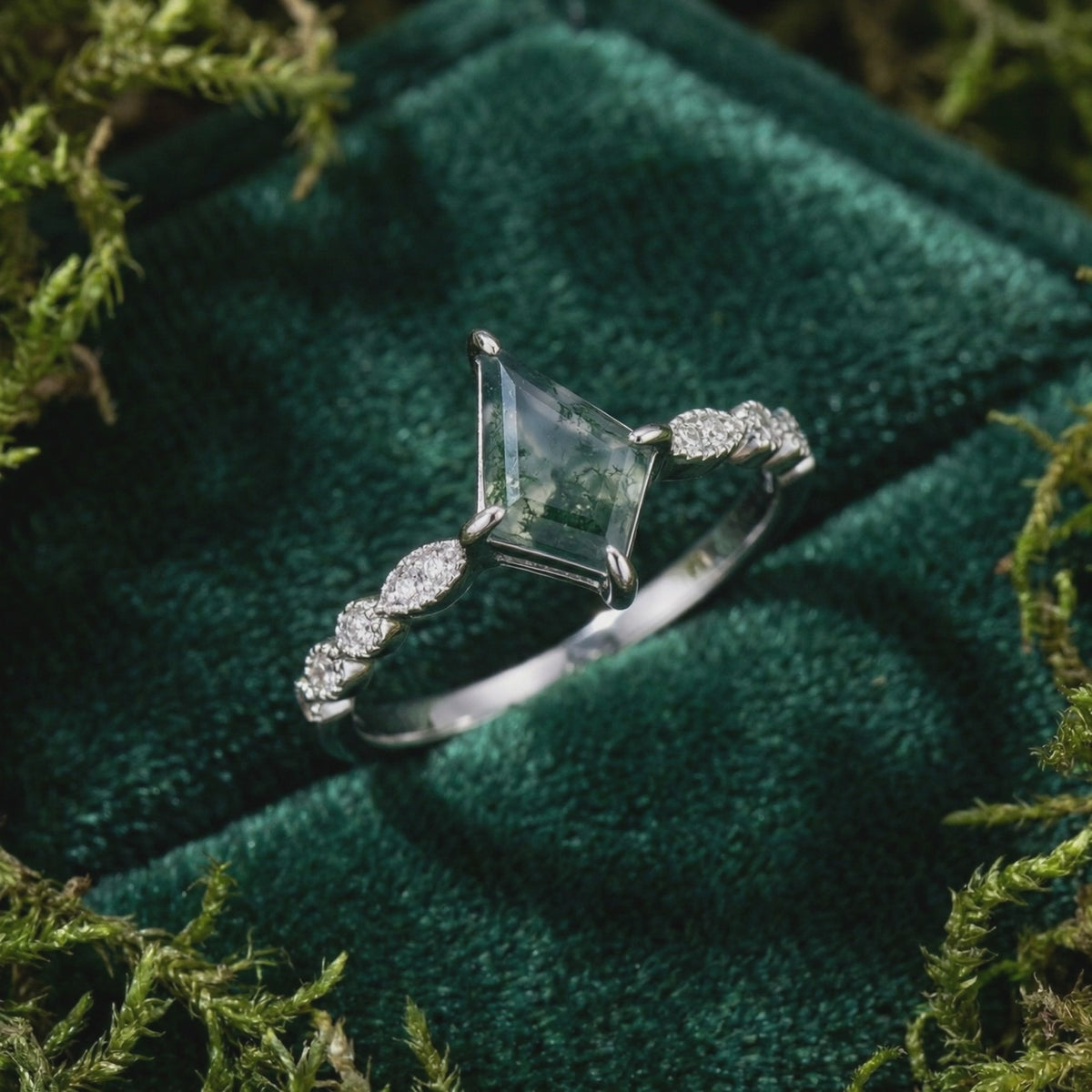 Kite cut natural moss agate ring in solid white gold on dark green velvet with moss.