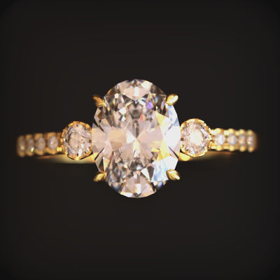 A ring with an oval moissanite stone and solid gold material.