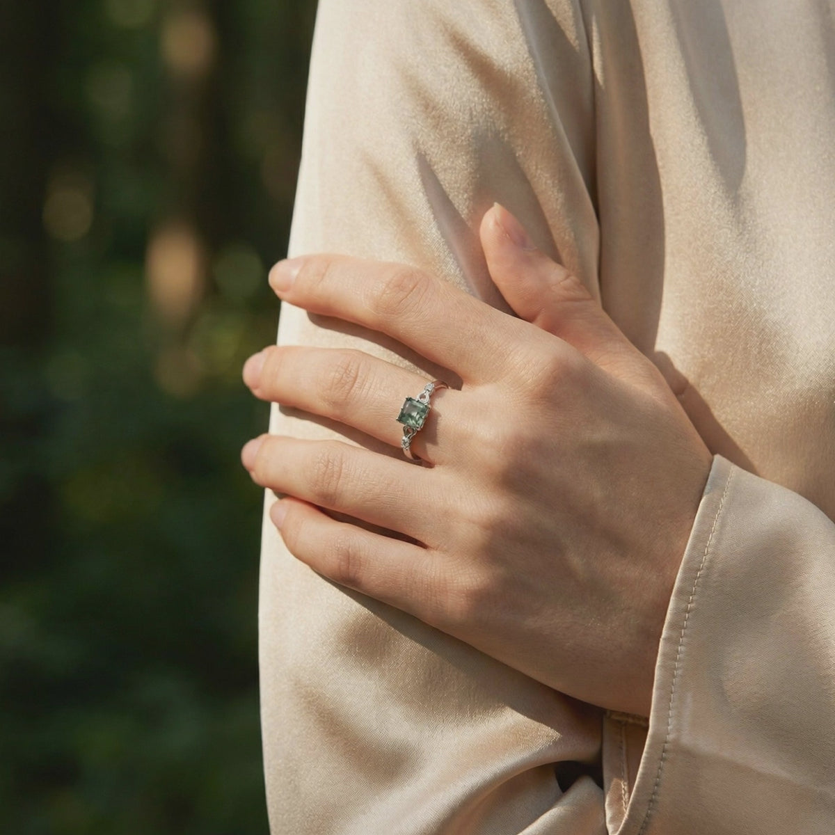 A solid gold cushion cut natural moss agate ring with a wavy band.