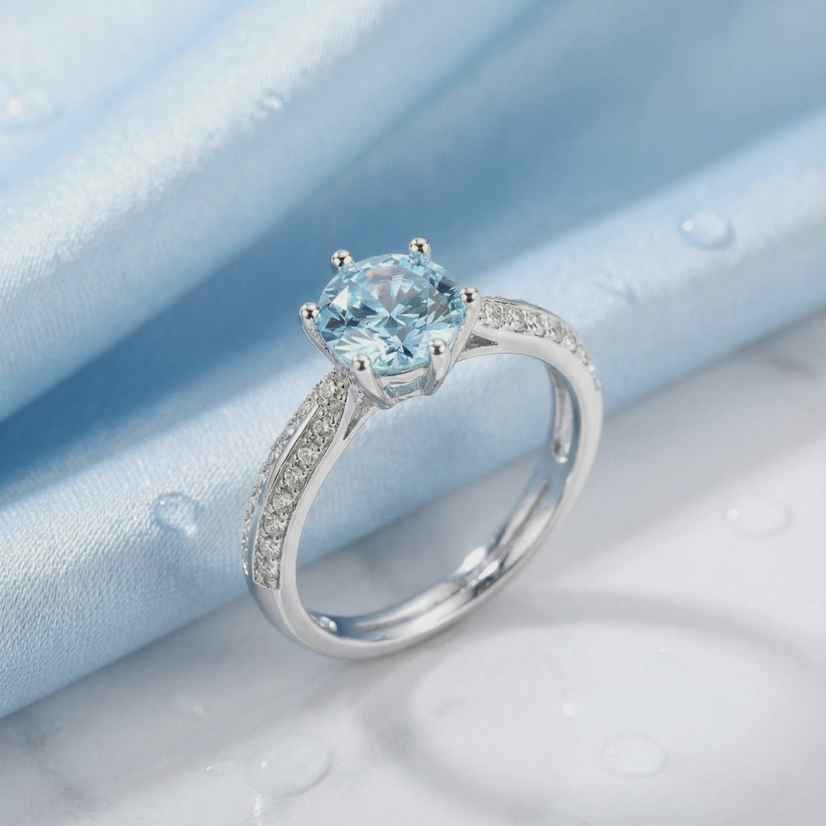 Close-up of a round simulated aquamarine solitaire ring in solid gold.