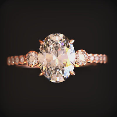 A ring with an oval moissanite stone and solid gold material.