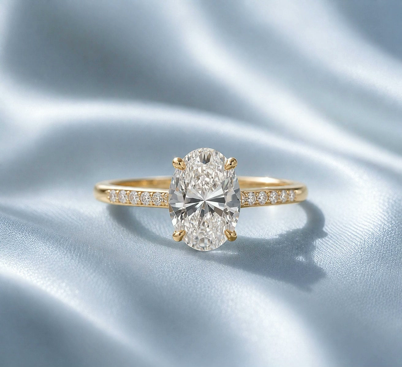 Custom oval engagement ring on powder-blue silk