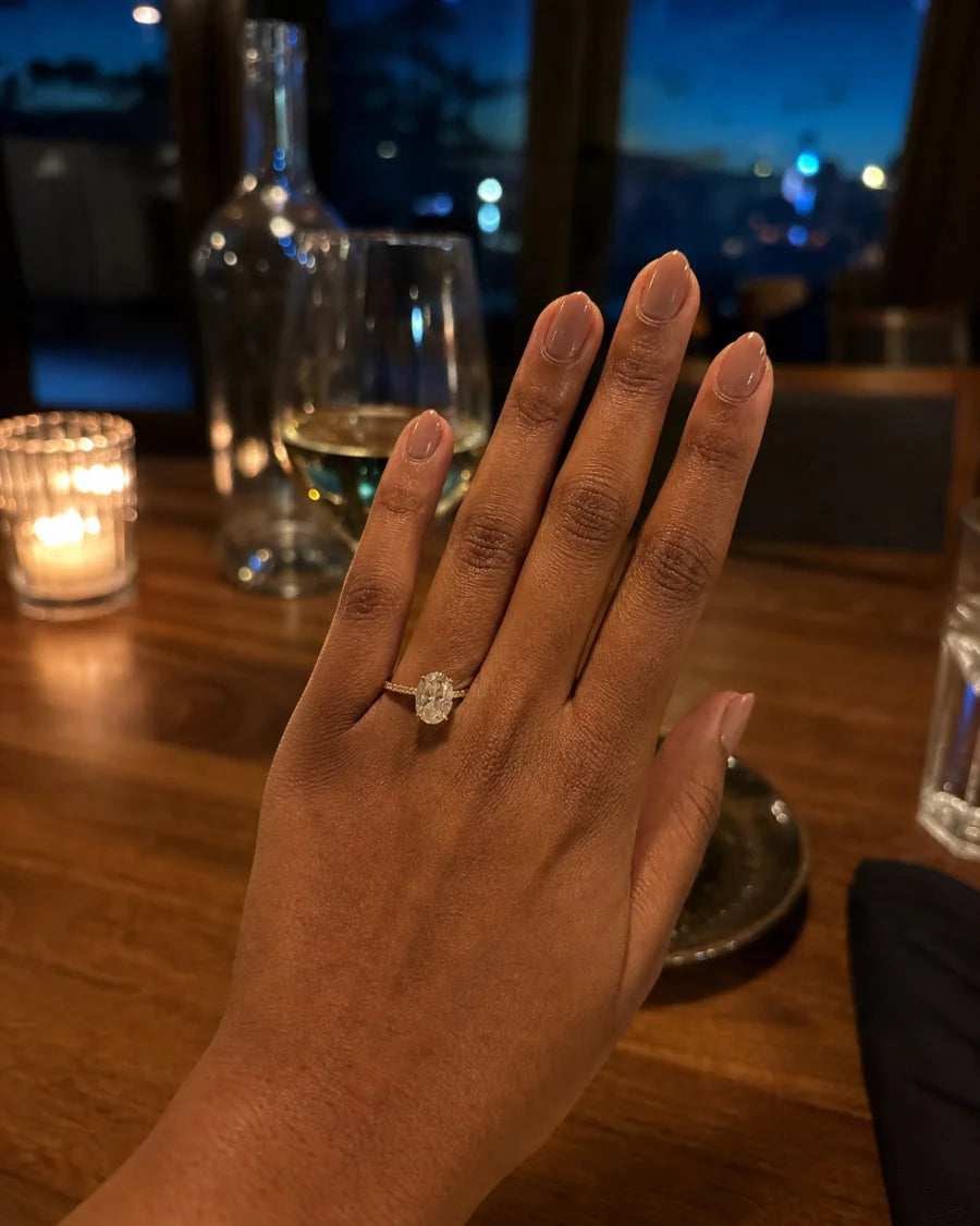 Oval engagement ring worn during an intimate restaurant celebration