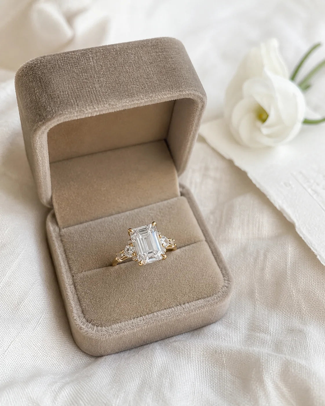 Emerald-cut engagement ring in a taupe velvet proposal box