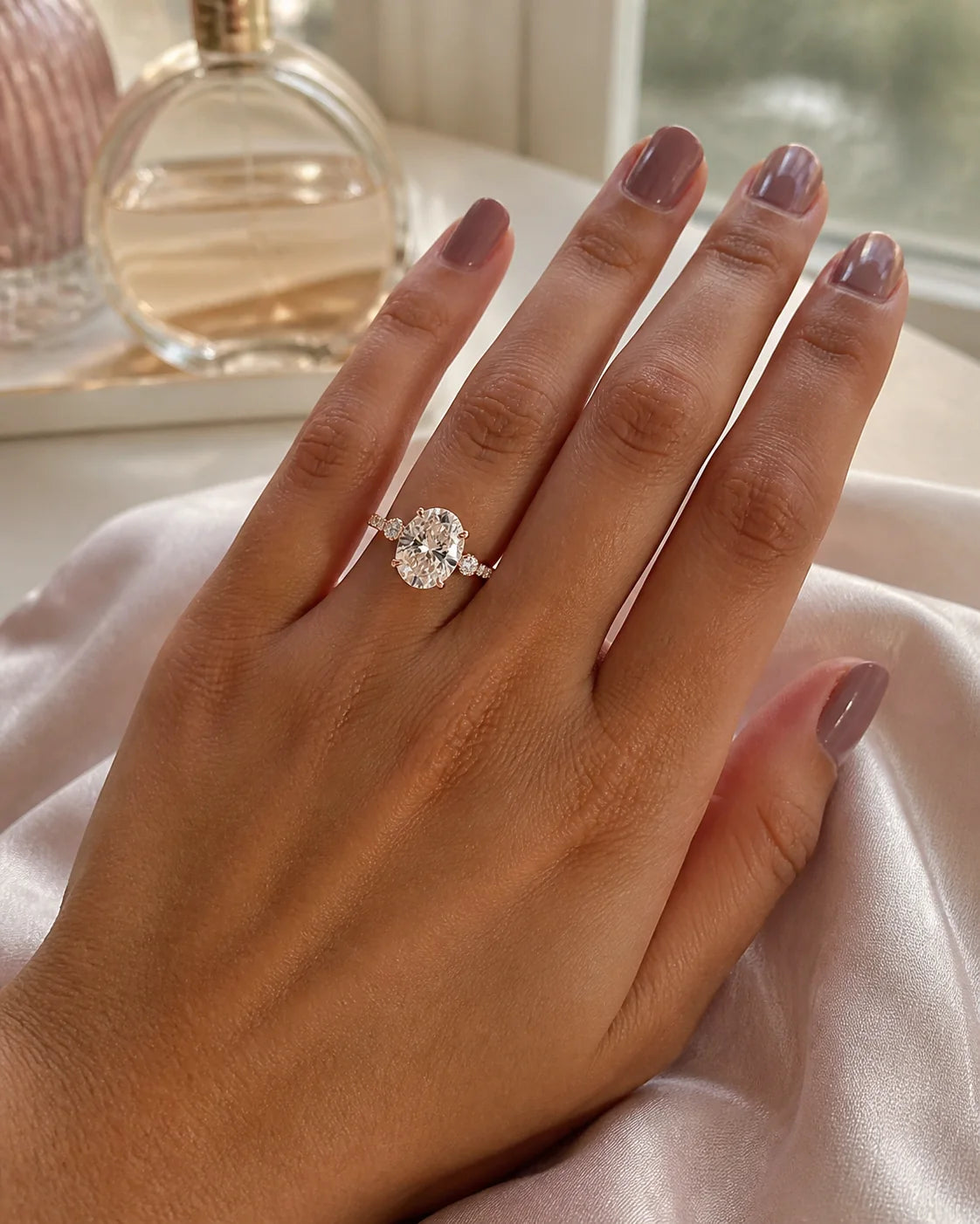Rose-gold oval engagement ring photographed on pale silk